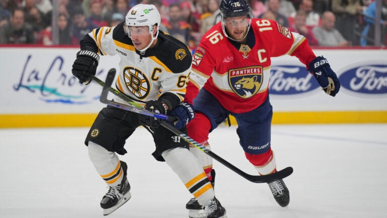 Bruins' Brad Marchand and Panthers' Aleksander Barkov battle for position.