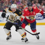 Bruins' Brad Marchand and Panthers' Aleksander Barkov battle for position.