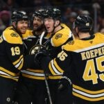 BOSTON, MASSACHUSETTS - OCTOBER 14: John Beecher #19 of the Boston Bruins celebrates with Cole Koepke #45, Mason Lohrei #6, and Mark Kastelic #47 after scoring a goal against the Florida Panthers during the first period at TD Garden on October 14, 2024 in Boston, Massachusetts.