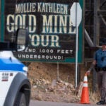 A police officer moves a barrier for an emergency vehicle Thursday, Oct. 9, 2024, at Mollie Kathleen Gold Mine in Cripple Creek, Colo.