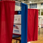FILE -- Voting booths are set up in a high school gymnasium in Hollis, N.H., Monday, Jan. 22, 2024.
