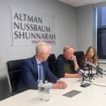 Thomas Flaws of Altman Nussbaum Shunnarah Trial Attorneys sits with Glenn Inghram's brother and niece at a press conference on Thursday where they announced plans to file a lawsuit against the MBTA.