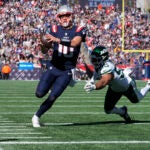 Drake Maye runs for a touchdown in front of Jets linebacker Chazz Surratt.