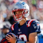 New England Patriots quarterback Drake Maye (10) dries his hands on a Gatorade towel during the first half of an NFL football game against the New York Jets on Sunday, Oct. 27, 2024, in Foxborough, Mass.