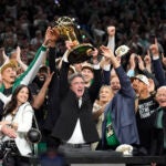 Celtics owner Wyc Grousbeck holds up the championship trophy.
