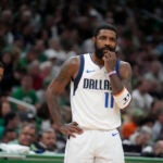 Dallas Mavericks guard Kyrie Irving pauses on the court in front of Boston Celtics head coach Joe Mazzulla, left, during the first half of Game 5 of the NBA basketball finals, Monday, June 17, 2024, in Boston.
