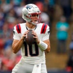 London, England- 10/20/24- New England Patriots quarterback Drake Maye (10) looks to throw against the Jacksonville Jaguars during the second quarter at Wembley Stadium.