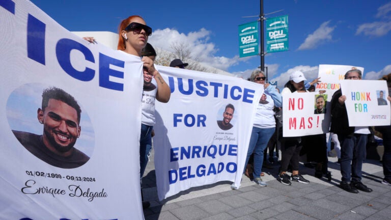 People display signs with with a likeness of Massachusetts State Police recruit Enrique Delgado-Garcia, who died following a State Police Academy training exercise, at a protest outside the State Police Academy graduation ceremony, Wednesday, Oct. 9, 2024, at the DCU Center, in Worcester, Mass.
