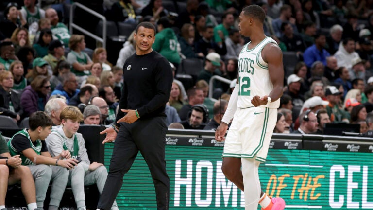 Joe Mazzulla speaks with Lonnie Walker IV during a preseason game against the Raptors.