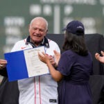 Joe Castiglione, radio voice of the Red Sox since 1983, receives a proclamation from Mayor Michelle Wu.