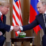 Donald Trump and Russian President Vladimir Putin shake hands.