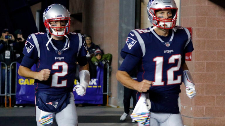 New England Patriots quarterbacks Brian Hoyer, left, and Tom Brady head to the field to warm up before an NFL football game against the Kansas City Chiefs in 2018. (Bill Sikes/AP)