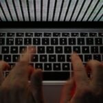 A stream of binary coding on a laptop computer screen.