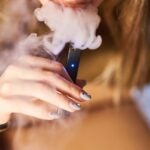 A person smokes a Juul Labs Inc. e-cigarette.