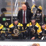 The Bruins bench is glum with seconds remaining in the game with them trailiung, 5-2, as coach Jim Montgomery stands behind (l to rt) Boston Bruins center Charlie Coyle (13), Boston Bruins left wing Brad Marchand (63), Boston Bruins center Pavel Zacha (18) and Boston Bruins center Elias Lindholm (28).
