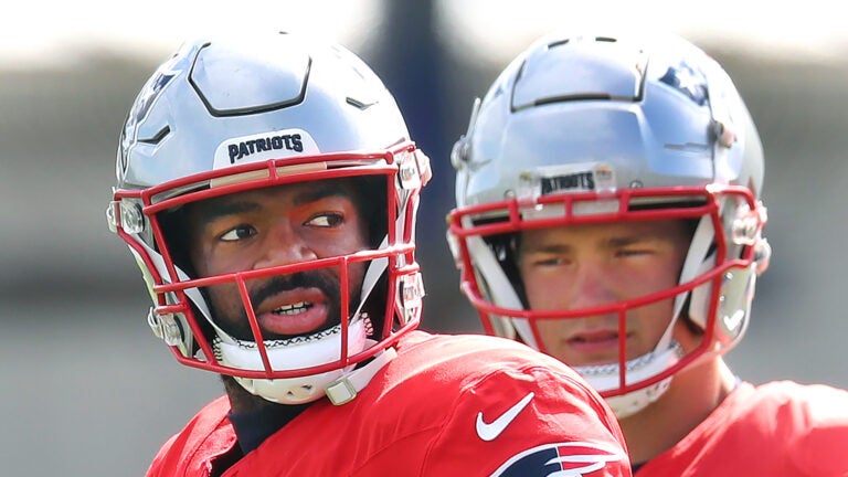 Foxborough10/02/2024 The patriots held practice on the Gillette Stadium practice field. Qb Drake Maye peers over qb Jacoby Brissett during a passing drill.