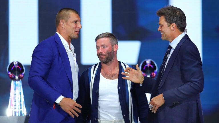 Rob Gronkowski(left) and Julian Edelman greet Tom Brady on stage. Former New England Patriots quarterback Tom Brady was inducted into the Patriots Hall of Fame during a ceremony at Gillette Stadium.