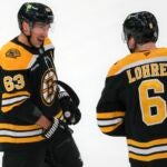 Boston Bruins left wing Brad Marchand (63) celebrates his game winning goal with teammate Mason Lohrei (6) against the Calgary Flames Calgary Flames during the overtime period NHL action at TD Garden.