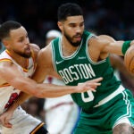 Boston Celtics forward Jayson Tatum (0) dribbles with pressure from Golden State Warriors guard Stephen Curry (30) in the fourth quarter at TD Garden.