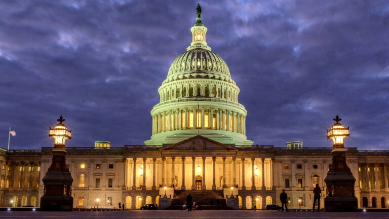 Lights shine inside the U.S. Capitol Building as night falls on Jan. 21, 2018, in Washington.