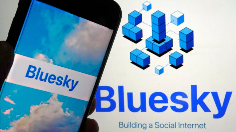 The app for Bluesky is shown on a mobile phone and on a laptop screen.