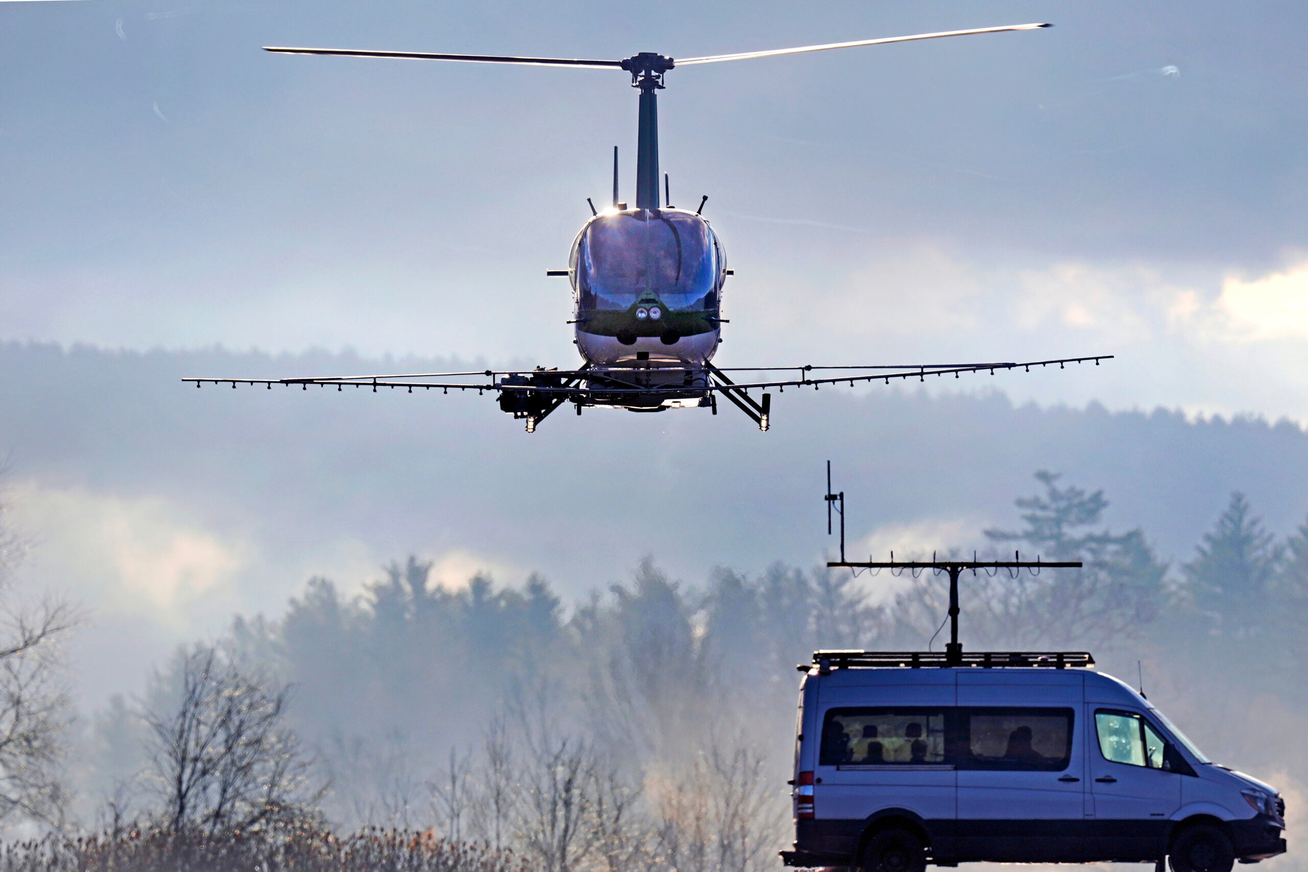 An unmanned semi-autonomous helicopter from Rotor Technologies drives away from a pickup truck.