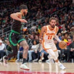 Trae Young drives the lane while guarded by Jayson Tatum during a game in Atlanta, Nov. 4, 2024.