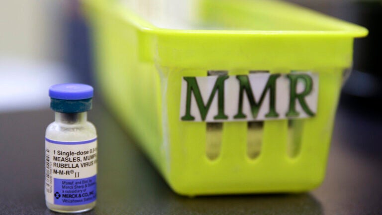 A vial of a measles, mumps and rubella vaccine sits on a countertop.