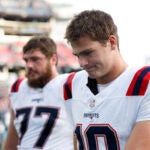 New England Patriots quarterback Drake Maye (10) and center Ben Brown (77) walk off the field after falling to the Tennessee Titans, 20-17, in overtime at Nissan Stadium.
