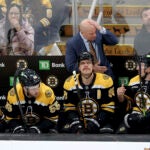 Boston Bruins head coach Jim Montgomery speaks to one of his players during the second period of an NHL hockey game against Seattle Kraken, Sunday, Nov. 3, 2024, in Boston.