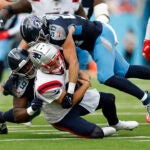 New England Patriots quarterback Drake Maye (10) is sacked by Tennessee Titans defensive tackle Sebastian Joseph-Day (69) and linebacker Jack Gibbens (50) during the third quarter at Nissan Stadium.
