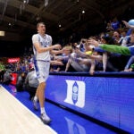 Cooper Flagg high-fives fans after a game against Maine.