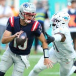 Miami Dolphins linebacker Emmanuel Ogbah (91) goes after New England Patriots quarterback Drake Maye (10) during the second half of an NFL football game, Sunday, Nov. 24, 2024, in Miami Gardens, Fla.