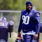 New England Patriots defensive tackle Christian Barmore (90) watches his teammates practice during an NFL football training camp, Friday, July 26, 2024, in Foxborough, Mass.