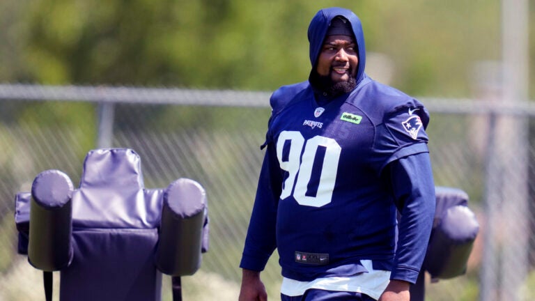 New England Patriots defensive tackle Christian Barmore (90) watches his teammates practice during an NFL football training camp, Friday, July 26, 2024, in Foxborough, Mass.