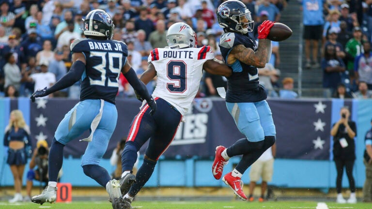 Titans safety Amani Hooker intercepts a pass intended for Patriots wide receiver Kayshon Boutte.