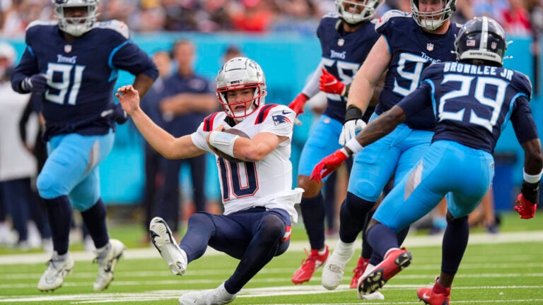 Drake Maye slides after a run against the Titans.