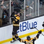 Bruins center Elias Lindholm celebrates after scoring with right wing David Pastrnak and left wing Brad Marchand during the second period.