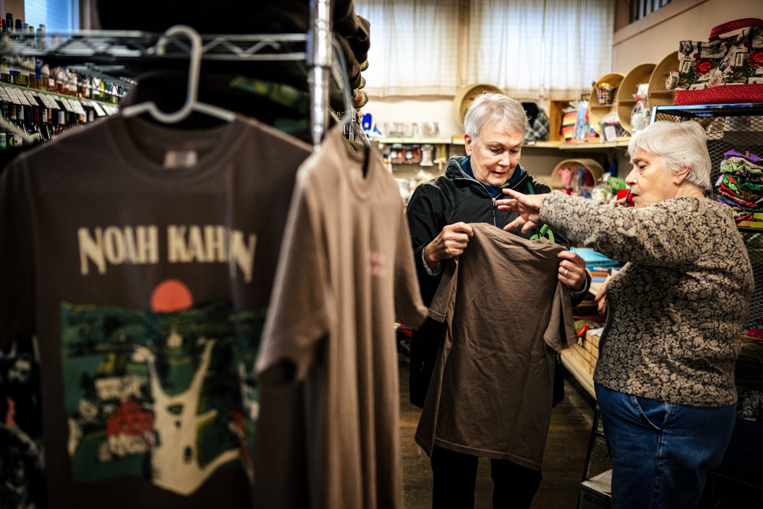 Sue Coburn, à direita, ajuda a cliente Joanne Ryan a escolher uma camiseta da marca Coburns' General Store.