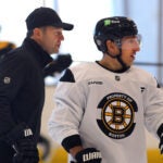 Boston-11/20/2024 The Boston Bruins held practice at Warrior Ice Arena under their new coach, Joe Sacco after Jim Montgomery was fired as the head coach. Sacco skates by Brad Marchand as they chatduring practice. John Tlumacki/Globe Staff (sports)