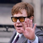 Elton John waves to the waiting media.