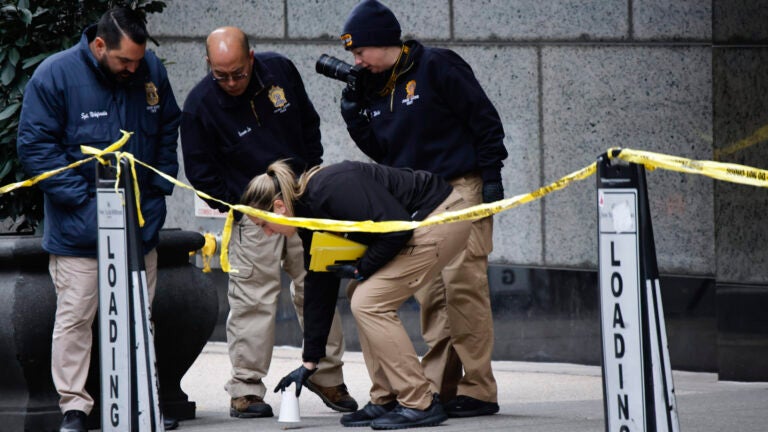 Members of the New York police crime scene unit pick up cups.