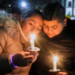 Supporters hold candles during a candlelight vigil.