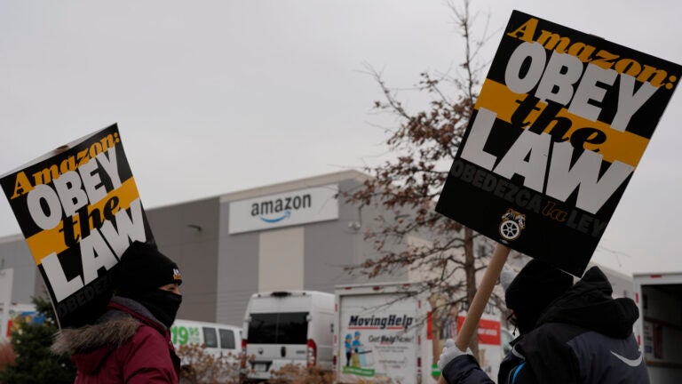 Strikers hold signs during a strike at Skokie (DIL7) Amazon Delivery station in Skokie, Ill.