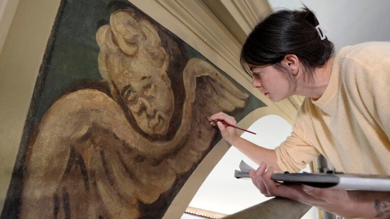 Conservator Corrine Long, of Dover, N.H., restores nearly 300-year-old painted angels on walls of Old North Church.