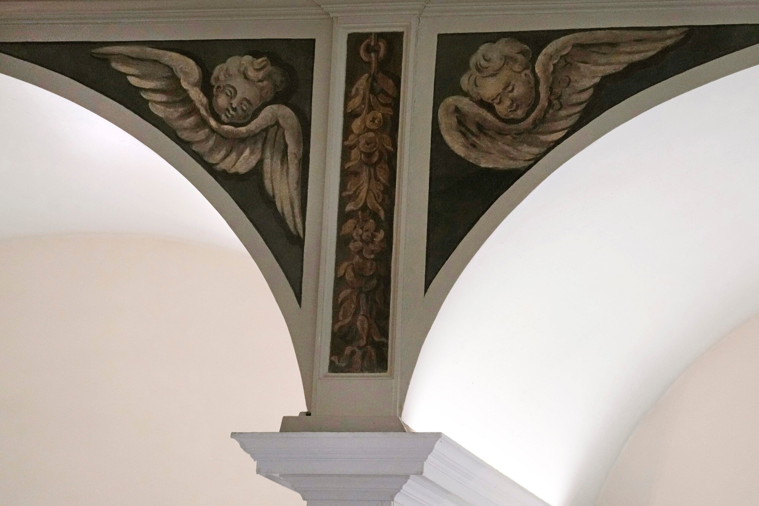 Recently restored, nearly 300-year-old painted angels adorn an arch.