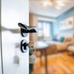 Open door with keys, key in keyhole home buyer adobe stock