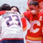 Sean Monahan hugs Johnny Gaudreau's mother as his father looks on before a game against the Flames.