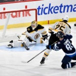 Winnipeg Jets' Kyle Connor scores on Bruins goaltender Jeremy Swayman during the third period.