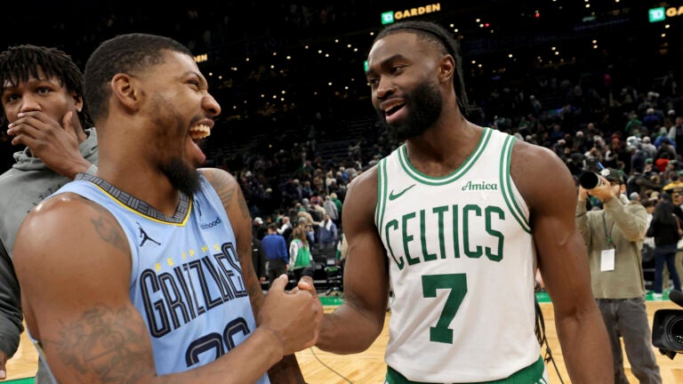 Memphis Grizzlies guard Marcus Smart, left, shares a laugh and a fist bump with former Celtics teammate Jaylen Brown (7) at the end of an NBA basketball game, Saturday, Dec. 7, 2024, in Boston.